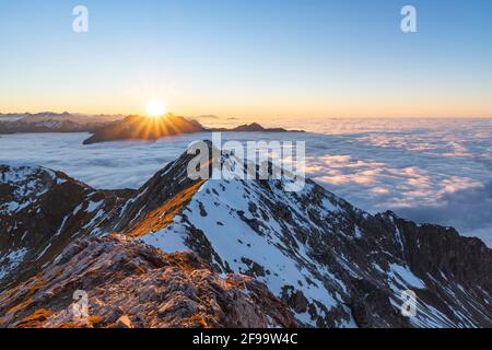 Sonnenuntergang im Herbst schneebedeckte Berge über Wolkendecke. Blick vom Gaishorn auf die Allgäuer Alpen. Bayern, Deutschland, Europa Stockfoto