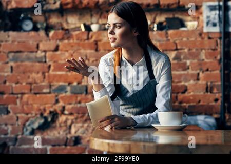 Eine Kellnerkaffeetasse in der Nähe der Wand des Tisches Stockfoto