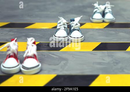 Konzept der sozialen Distanzierung. Turnschuhe und Warnband auf dem Asphalt-Hintergrund. Speicherplatz kopieren. Halten Sie Abstand, um die Ausbreitung des Virus zu verhindern. Neu Stockfoto