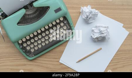Eine Vintage-Schreibmaschine mit Papierblättern, Schablone und Papierkugeln. Stockfoto