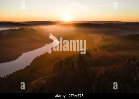 Ein einziger Arm der Bleilochtalsperre schlängelt sich durch den Wald In Richtung der aufgehenden Sonne Stockfoto