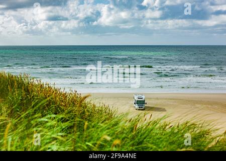 Wohnmobil an einem Sandstrand am Meer Stockfoto