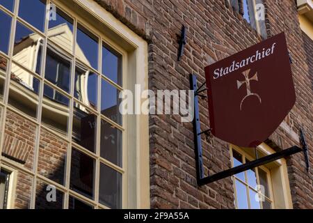 ZUTPHEN, NIEDERLANDE - Mar 19, 2021: Spiegelung der historischen Fassade im Außenfenster der lokalen Gemeinde Archivinstitution. ÜBERSETZUNG: 'CITY AR Stockfoto