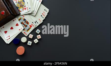 Spielkarten und Würfel auf einem dunkelgrauen Hintergrund. Stockfoto