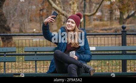 Junge Frau sitzt auf einer Bank im Central Park New York - Reisefotografie Stockfoto