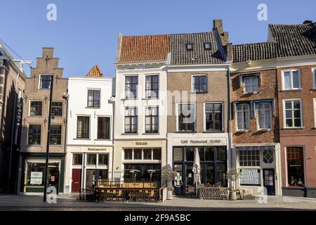 ZUTPHEN, NIEDERLANDE - Mär 19, 2021: Schiefe historische mittelalterliche Außenfassaden in der Hansestadt vor einem klaren blauen Himmel. Stockfoto