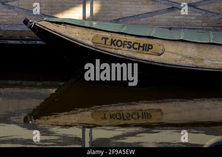 ZUTPHEN, NIEDERLANDE - Mar 19, 2021: Flüsterboot vor Anker liegend, spiegelnd und spiegelnd im stillen Wasser, benannt nach einer niederländischen grammatischen Regel 't KOF Stockfoto