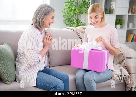 Foto von glücklich positive nette Familie sitzen Couch halten präsent Frauen Tag gute Laune drinnen im Haus Stockfoto