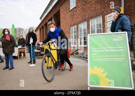 Steinbergkirche, Deutschland. April 2021. Robert Habeck (M), Bundesvorsitzender von Bündnis 90/die Grünen, kommt mit dem Fahrrad zu einer Mitgliederversammlung der Grünen zur Wahl des Direktkandidaten für den Bundestag. Die Grünen der Stadt Flensburg und des Landkreises Schleswig-Flensburg wollen bei der Veranstaltung in der Steinbergkirche ihren Direktkandidaten für die Bundestagswahl im September 2021 nominieren. Der einzige Kandidat ist bisher Parteiführer Habeck. Quelle: Christian Charisius/dpa/Alamy Live News Stockfoto