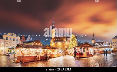 Tallinn, Estland. Traditioneller Weihnachtsmarkt Am Rathausplatz. Handel Mit Häusern Mit Verkauf Von Weihnachtsgeschenken. Nachthimmel Über Dem Berühmten Wahrzeichen Stockfoto