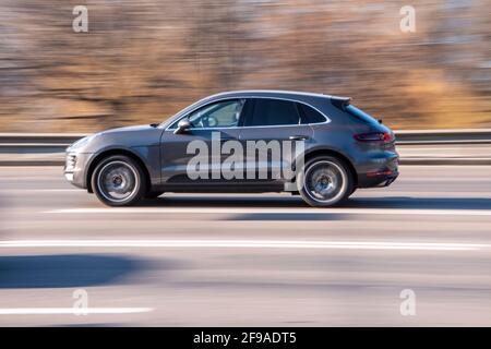 Ukraine, Kiew - 11. März 2021: Graues Porsche Macan-Auto fährt auf der Straße; Stockfoto