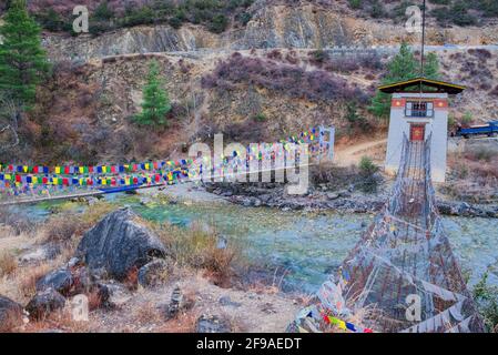 Die Tachogang Lhakhang-Brücke, die im Volksmund als Eiserne Kettenbrücke bekannt ist, überquert den Paro Chhu zum Dzong. Diese 600 Jahre alte Brücke wurde von Than gebaut Stockfoto