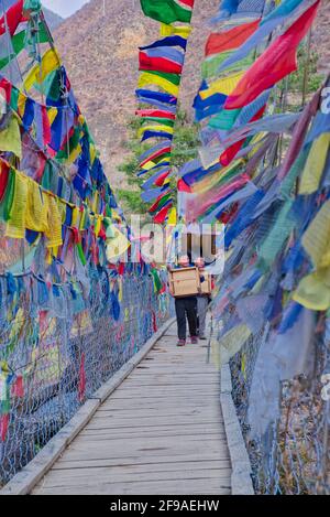 Die Tachogang Lhakhang-Brücke, die im Volksmund als Eiserne Kettenbrücke bekannt ist, überquert den Paro Chhu zum Dzong. Diese 600 Jahre alte Brücke wurde von Than gebaut Stockfoto