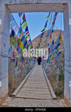 Die Tachogang Lhakhang-Brücke, die im Volksmund als Eiserne Kettenbrücke bekannt ist, überquert den Paro Chhu zum Dzong. Diese 600 Jahre alte Brücke wurde von Than gebaut Stockfoto