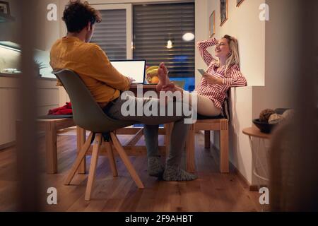 Junges Paar genießen zusammen, arbeiten von zu Hause aus, verbringen valentine in Isolation. Valentine während covid Lockdown Konzept Stockfoto