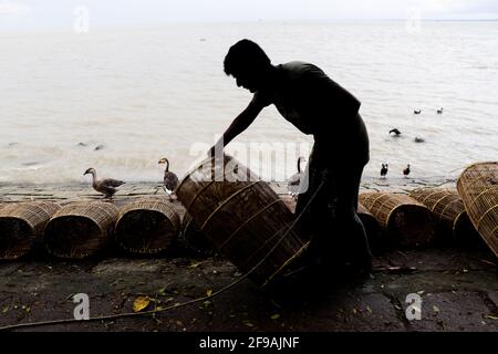 Fischer, der sich am Flussufer für das Fischen mit Käfig und Seil vorbereite Ich habe dieses Bild am 15. September 2020 aus Chandpur, Bangladesch, aufgenommen Stockfoto