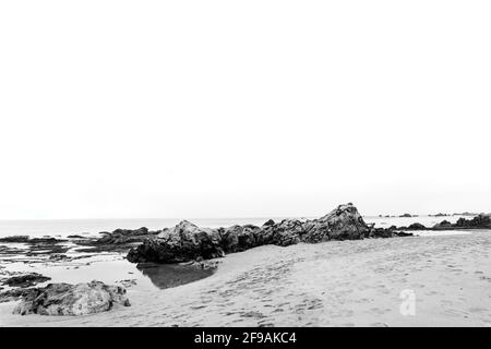 Schwarz-weißer Felsen am strand von legon Pari in Sawarna 2 Stockfoto