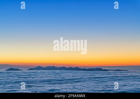 Nach Sonnenuntergang erheben sich Berge aus dem Meer der Wolken. Nagelfluhkette, Allgäuer Alpen. Bayern, Deutschland, Europa Stockfoto