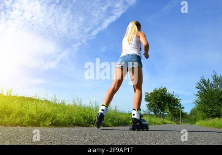 Teenager Mädchen auf Rollschuhe im Sommer. Inline-Skating auf der Straße. Stockfoto