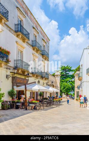 LOCOROTONDO, ITALIEN, 21. JUNI 2014: Blick auf eine weiße schmale Straße in der italienischen Stadt Locorotondo Stockfoto