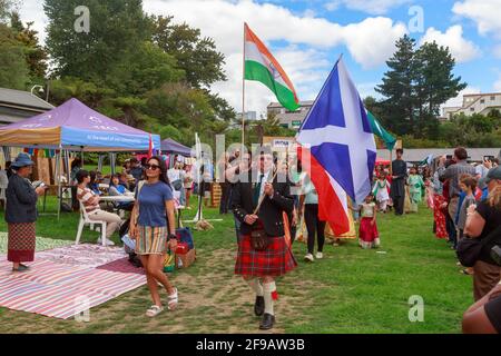 Ein schottischer Mann mit einem Kilt und der Flagge Schottlands führt eine multikulturelle Parade an. Tauranga, Neuseeland Stockfoto