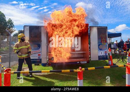Ein Feuerwehrmann, der demonstriert, was passiert, wenn Wasser auf ein Ölfeuer geworfen wird, erzeugt einen riesigen Feuerball. Sicherheitsdemonstration in Auckland, Neuseeland Stockfoto