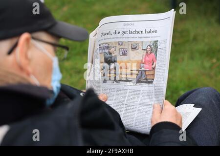 Steinbergkirche, Deutschland. April 2021. Ein Mitglied von Bündnis 90/die Grünen liest einen Zeitungsartikel mit einem Foto, das die beiden Parteivorsitzenden R. Habeck und A. Baerbock bei einer Mitgliederversammlung der Grünen zur Wahl des Direktkandidaten für den Bundestag zeigt. Die Grünen der Stadt Flensburg und des Landkreises Schleswig-Flensburg wollen bei der Veranstaltung in der Steinbergkirche ihren Direktkandidaten für die Bundestagswahl im September 2021 vorstellen. Der einzige Kandidat ist bisher Parteiführer Habeck. Quelle: Christian Charisius/dpa/Alamy Live News Stockfoto