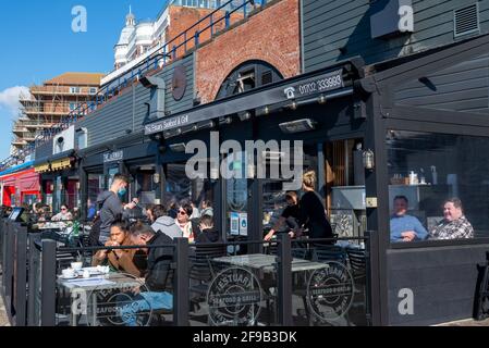 Southend on Sea, Essex, Großbritannien. April 2021. Die Küstenstadt Southend on Sea erwartet einen geschäftigen Tag, da Großbritannien Schritt 2 der Roadmap außer Betrieb setzt. Das prognostizierte schöne Wetter zieht die Menschen an die Küste an, mit einer Reihe von Cafés, die Speisen im Freien anbieten. Menschen essen in den Arches Restaurants Stockfoto