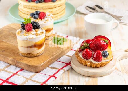 Süße Desserts mit frischen Beeren auf Holzhintergrund. Stockfoto