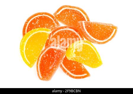 Orangefarbene und gelbe Scheiben süßer Fruchtmarmelade in Zucker isoliert auf weißem Hintergrund. Studio Photo Stockfoto