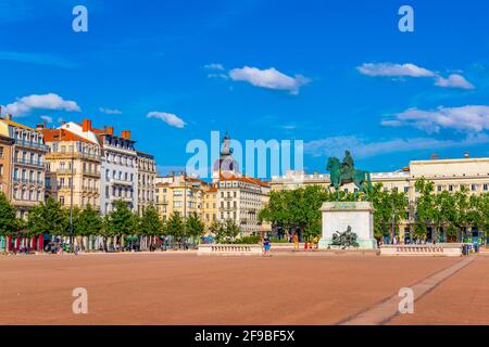 LYON, FRANKREICH, 23. JULI 2017: Die Menschen passieren die Statue von Ludwig XIV. Auf dem Place Bellecour in Lyon, Frankreich Stockfoto