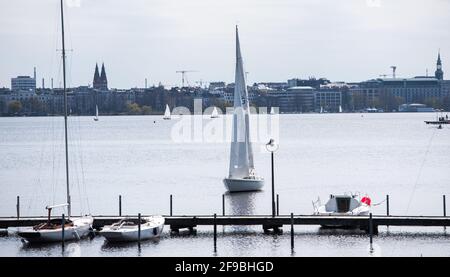 Hamburg, Deutschland. April 2021. Ein Segelboot passiert einen verlassenen Steg auf der Außenalster. Quelle: Daniel Bockwoldt/dpa/Daniel Bockwoldt/dpa/Alamy Live News Stockfoto