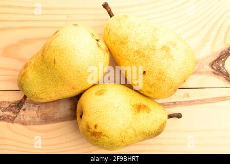 Drei hellgelbe Bio, reif, saftig, süße Birnen, Nahaufnahme, Auf einem Holztisch. Stockfoto