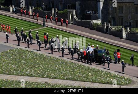 Der Sarg des Herzogs von Edinburgh, der mit seinem persönlichen Standard bedeckt ist, wird auf dem eigens gebauten Land Rover Defender getragen, gefolgt von der Prinzessin Royal, dem Prinz von Wales, dem Herzog von York, dem Earl of Wessex, dem Herzog von Cambridge, Peter Phillips, dem Herzog von Sussex, dem Earl of Snowdon, Vize-Admiral Sir Timothy Laurence vor der St. George's Chapel, Windsor Castle, Bestattungsanstellung des Herzogs von Edinburgh. Bilddatum: Samstag, 17. April 2021. Stockfoto