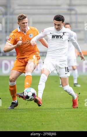 Augsburg, Deutschland. April 2021. Fußball: Bundesliga, FC Augsburg - Arminia Bielefeld, Matchday 29 in der WWK Arena. Joakim Nilsson von Arminia Bielefeld (l.) und Ruben Vargas vom FC Augsburg im Duell um den Ball. Quelle: Matthias Balk/dpa - WICHTIGER HINWEIS: Gemäß den Bestimmungen der DFL Deutsche Fußball Liga und/oder des DFB Deutscher Fußball-Bund ist es untersagt, im Stadion und/oder vom Spiel aufgenommene Fotos in Form von Sequenzbildern und/oder videoähnlichen Fotoserien zu verwenden oder zu verwenden./dpa/Alamy Live News Stockfoto