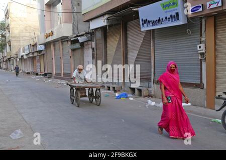 Beawar, Indien. April 2021. Straßenhändler gehen während der Sperrstunde am Wochenende vor geschlossenen Geschäften in einem Marktgebiet durch, die von der Landesregierung verhängt wurde, inmitten der Zunahme von Coronavirus-Fällen im ganzen Land, in Beawar. (Foto: Sumit Saleswat/Pacific Press) Quelle: Pacific Press Media Production Corp./Alamy Live News Stockfoto