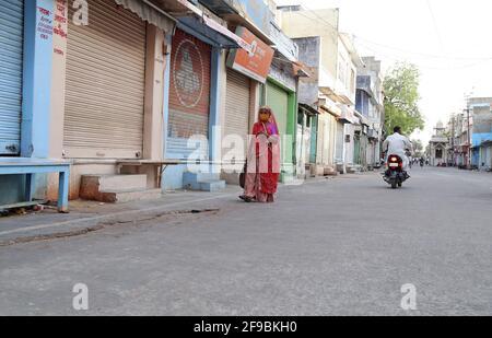 Beawar, Indien. April 2021. Eine Frau geht während der Sperrstunde am Wochenende, die von der Landesregierung verhängt wurde, vor geschlossenen Geschäften auf einem Markt durch, inmitten der Zunahme von Coronavirus-Fällen im ganzen Land, in Beawar. (Foto: Sumit Saleswat/Pacific Press) Quelle: Pacific Press Media Production Corp./Alamy Live News Stockfoto