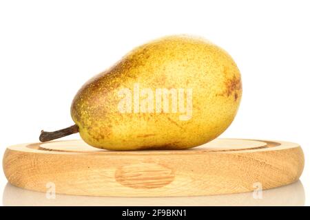 Eine hellgelbe Bio-Birne, reif, saftig, süß auf einem runden Bambustablett, Nahaufnahme, auf weißem Grund. Stockfoto