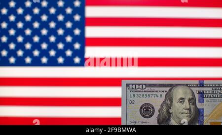 100 US-Dollar Banknote Nahaufnahme auf verschwommenem Hintergrund von USA-Flagge Stockfoto