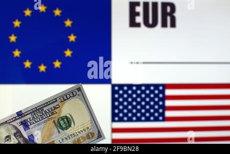 100 US-Dollar-Banknote auf verschwommenem Hintergrund von EU- und US-Flaggen und EU-Währungscode. Wechselkursvorlage Stockfoto