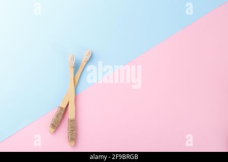 Natürliche Bambuszahnbürsten auf rosa blauem Hintergrund, keine Abfallprodukte, natürliche Mundhygiene Stockfoto