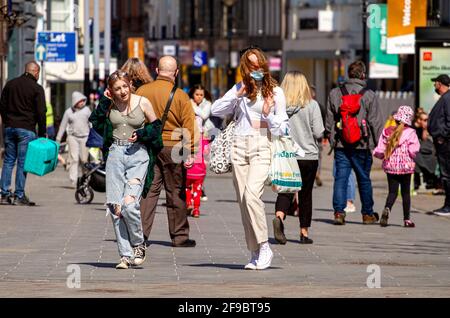 Dundee, Tayside, Schottland, Großbritannien. April 2021. UK Wetter: Schöner Frühlingssonne in Nordostschottland mit Temperaturen von bis zu 14 Grad Die Sperrung von Covid-19 wird gelockert, da die Menschen im Stadtzentrum von Dundee zusammenkommen und wichtige Einzelhandelsgeschäfte immer noch geöffnet sind. Zwei junge, modische Frauen nutzen die neuen, entspannten Sperrbestimmungen und das sonnige Aprilwetter, die nach einem Tag beim Shoppen gemeinsam Spaß haben. Kredit: Dundee Photographics/Alamy Live Nachrichten Stockfoto