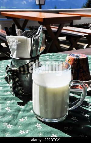 Imbiss auf einer Alm, die Buttermilch wird bereits in einem großen Krug serviert, Stockfoto