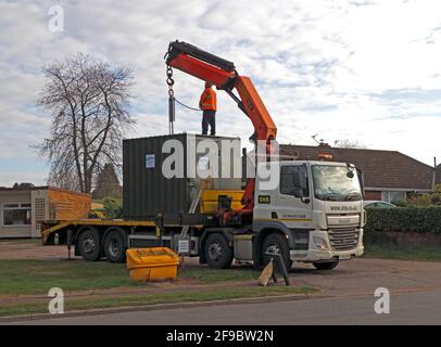 Eine temporäre mobile Einheit, die vorbereitet wird, um von einem Transportfahrzeug in der Nähe einer Baustelle in Hellesdon, Norfolk, England, Großbritannien, entladen zu werden. Stockfoto