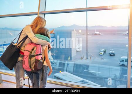 Fluggäste Familie Mutter und Tochter Kind Blick auf Flugzeuge Im Panoramafenster Stockfoto