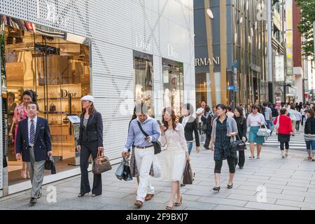Japanisches Publikum, das an Dior- und Armani-Geschäften in Ginza, Tokio, Japan vorbeikommt Stockfoto