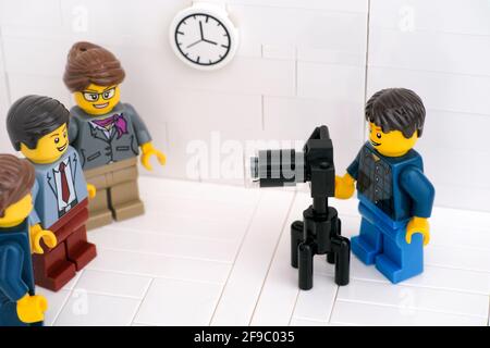 Tambow, Russische Föderation - 24. März 2021 EIN Lego-Fotograf fotografiert Lego-Geschäftsleute in ihrem Büro. Stockfoto