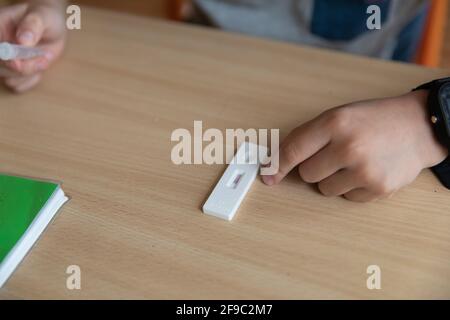 Der Junge wird vor der Klasse auf covid-19 getestet. Stockfoto