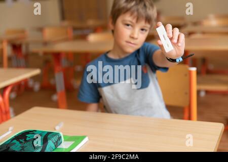 Der Junge wird vor der Klasse auf covid-19 getestet. Stockfoto