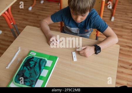 Der Junge wird vor der Klasse auf covid-19 getestet. Stockfoto